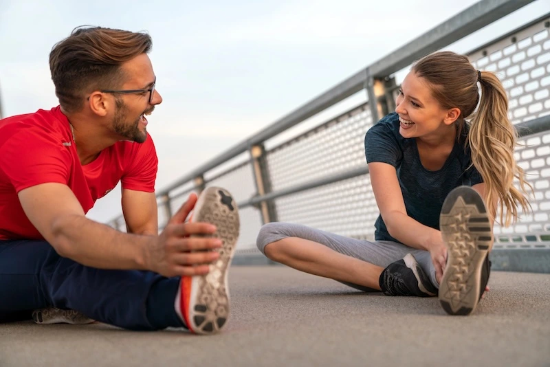 Biokineticist and client stretching for a run