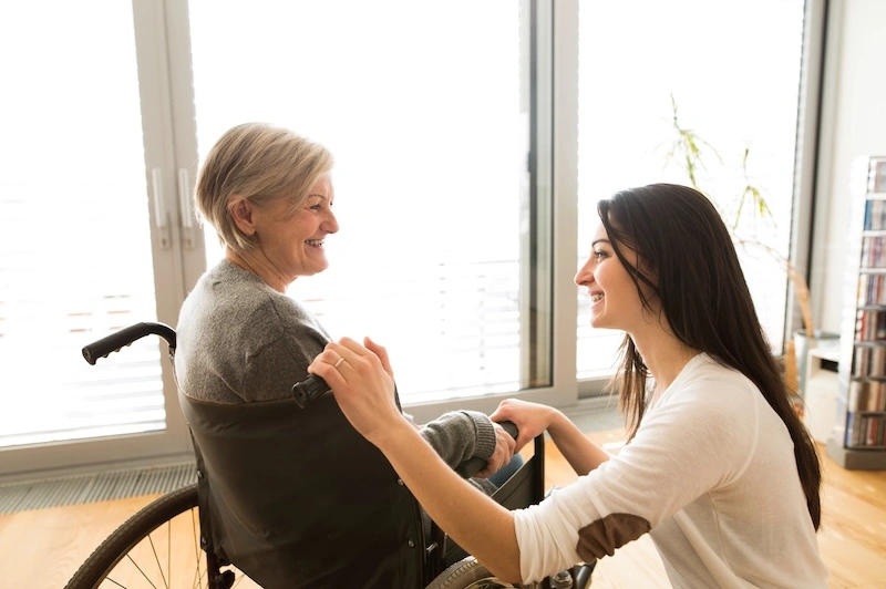 Occupational Therapist smiling at a woman in a wheelchair